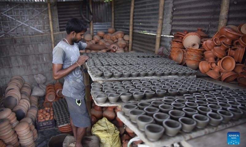 A potter arranges earthen lamps made for Diwali, the Hindu Festival of Lights, in Nagaon district of India's northeastern state of Assam, Oct. 21, 2021. Photo: CFP