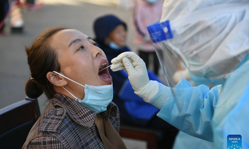 A medical worker takes a swab sample from a resident for nucleic acid test at a residential area in Ejina Banner of Alxa League, north China's Inner Mongolia Autonomous Region, Oct. 20, 2021. Photo: Xinhua