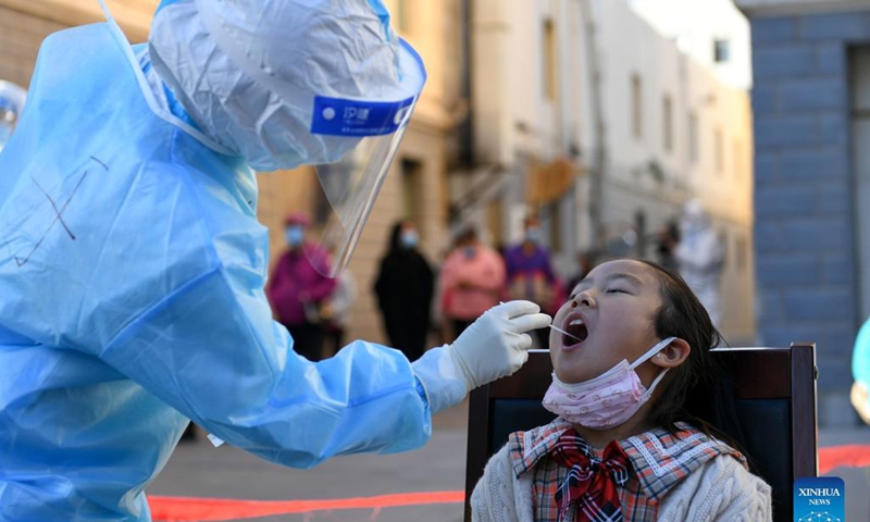 A medical worker takes a swab sample from a child for nucleic acid test at a residential area in Ejina Banner of Alxa League, north China's Inner Mongolia Autonomous Region, Oct. 20, 2021.Photo: Xinhua