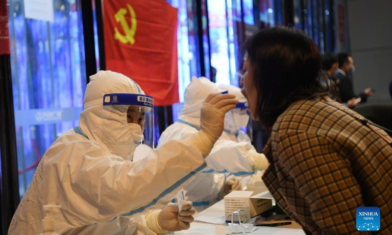 A medical worker collects swab samples at a nucleic acid testing site in Chengguan District of Lanzhou City, northwest China's Gansu Province, Oct. 21, 2021.Photo:Xinhua