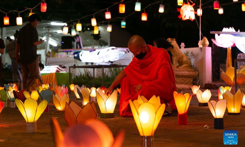 A monk lights a lantern in a temple at the end of the Buddhist Lent in Lao capital Vientiane, Oct. 21, 2021.Photo:Xinhua