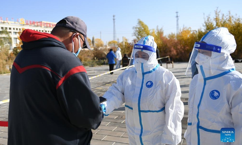 A staff member helps a resident to register for nucleic acid test at a nucleic acid testing site in Ejina Banner of Alxa League, north China's Inner Mongolia Autonomous Region, Oct. 22, 2021.Photo:Xinhua