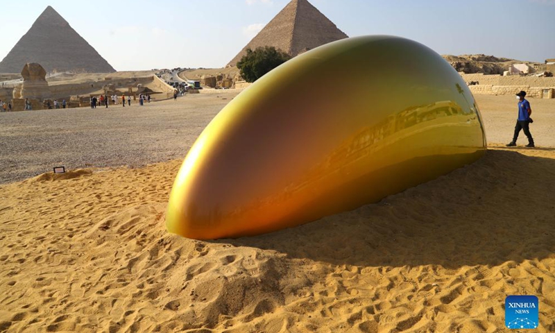 Photo taken on Oct. 21, 2021 shows an artwork in front of Giza Pyramids during an international art exhibition in Giza, Egypt. Egypt launched on Thursday the first international art exhibition at the Great Pyramids of Giza and their surrounding plateau with the participation of artists from Egypt and other countries.Photo:Xinhua