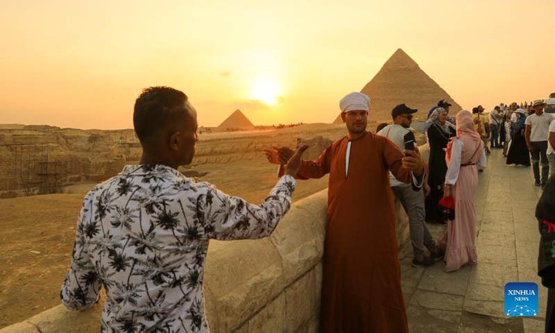 Tourists take photos while visiting the Giza Pyramids scenic spot in Giza, Egypt, on Oct. 21, 2021.Photo:Xinhua