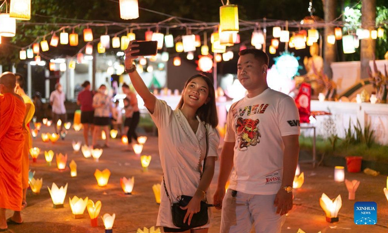 People take photos with lanterns in a temple at the end of the Buddhist Lent in Lao capital Vientiane, Oct. 21, 2021.Photo:Xinhua