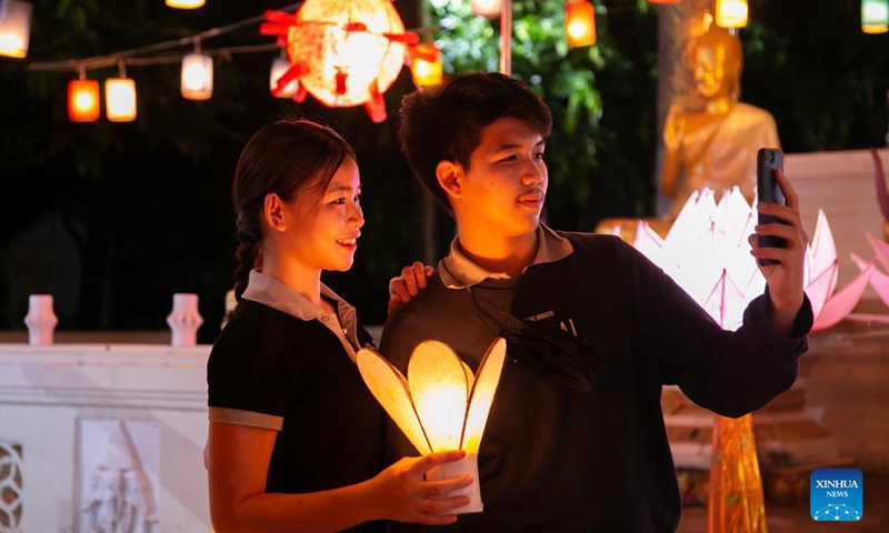 People take photos with lanterns in a temple at the end of the Buddhist Lent in Lao capital Vientiane, Oct. 21, 2021.Photo:Xinhua