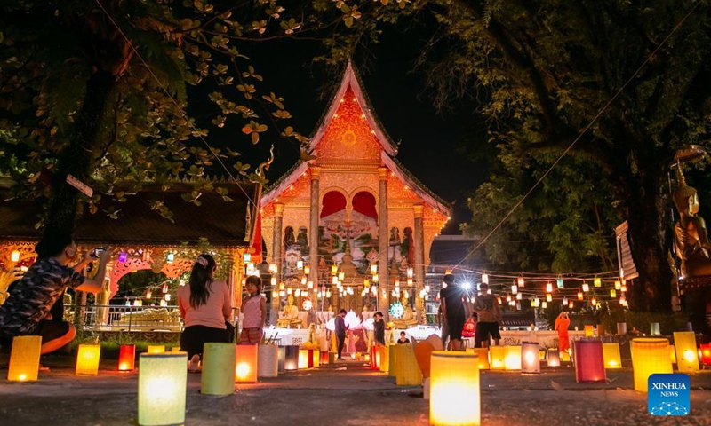 People take photos with lanterns in a temple at the end of the Buddhist Lent in Lao capital Vientiane, Oct. 21, 2021.Photo:Xinhua