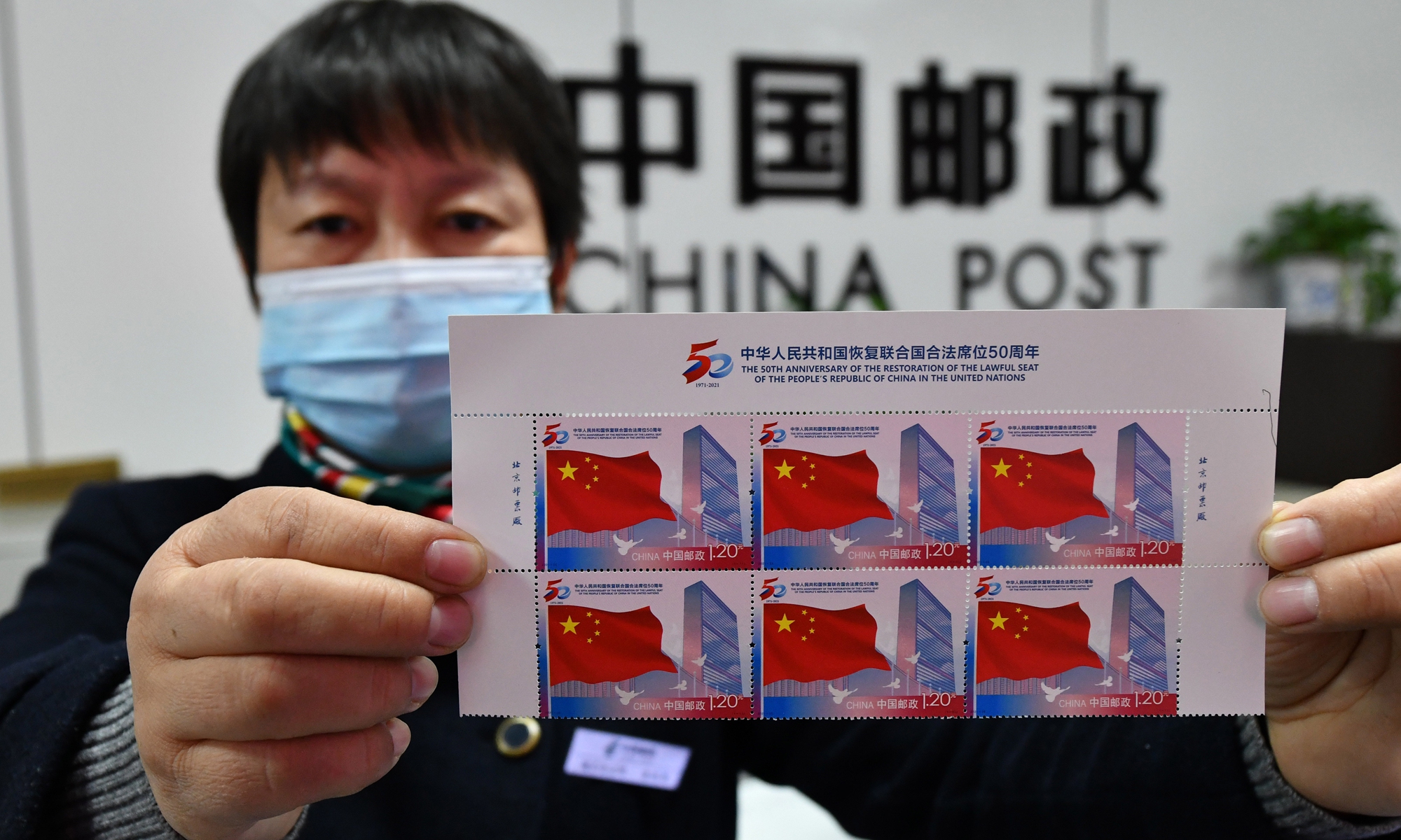 A post office staff member in East China's Anhui Province displays commemorative stamps for the 50th anniversary of the restoration of the lawful seat of the People's Republic of China in the United Nations. China Post will issue a set of commemorative stamps on October 25, 2021 to mark the anniversary.  Photo: cnsphoto