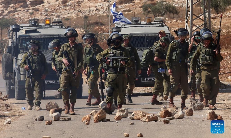 Israeli soldiers hold their weapons during clashes with Palestinian protesters during a protest against the expansion of Jewish settlements in the West Bank village of Beit Dajan, east of Nablus, on Oct. 22, 2021.(Photo: Xinhua)