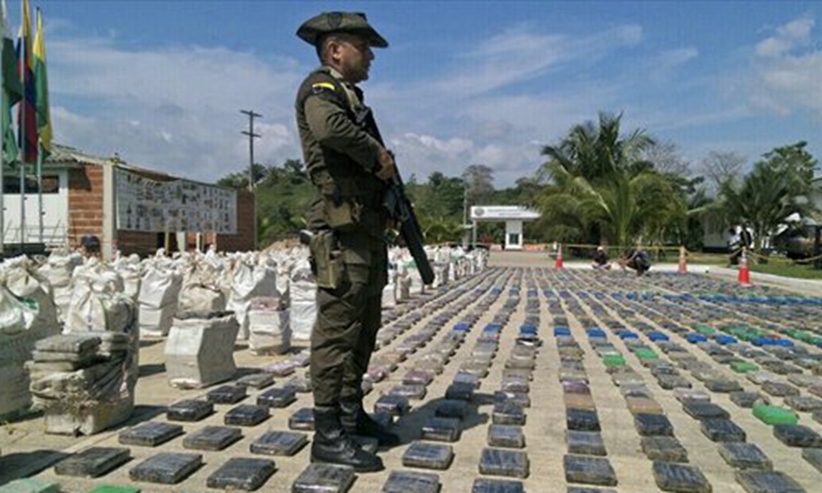 A Colombian police officer stands guard over eight tons of seized cocaine in Turbo, Antioquia, on Sunday. General Jorge Nieto, the head of the Colombian police, said the seized cocaine belonged to the Usuga clan. Photo: AFP