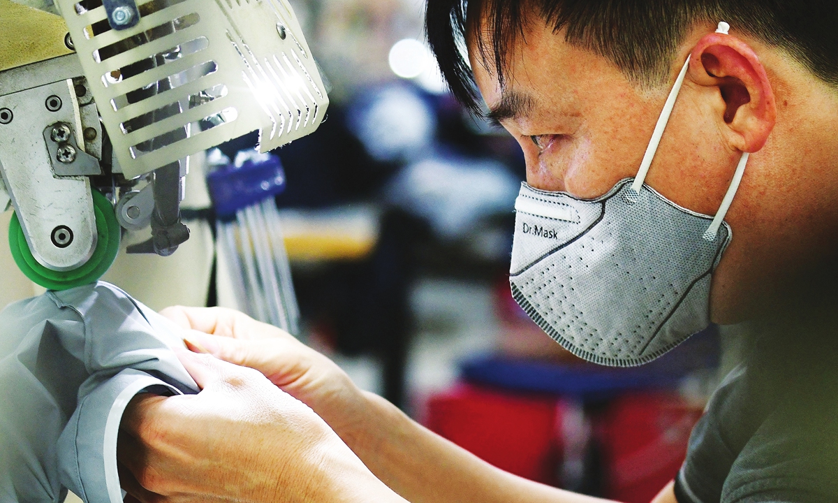 A worker wearing face mask makes activewear for various textile clothing brands at a factory in Hanoi on September 21, 2021. Photo: AFP
