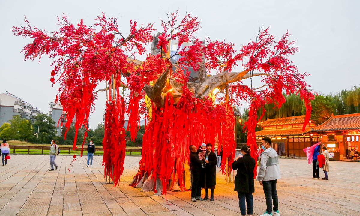 Luoyang, Central China's Henan Province, builds a fake tree for residents and tourists to write good wishes on it, attracting many to leave red strips of cloth to make a wish and take pictures. Photo: IC