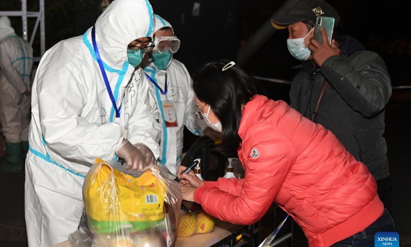 Staff members receive supplies at Furongli residential community in Haidian District in Beijing, capital of China, Oct. 26, 2021. Furongli has been put under closed-off management after one confirmed case of COVID-19 in the community on Oct. 24. 