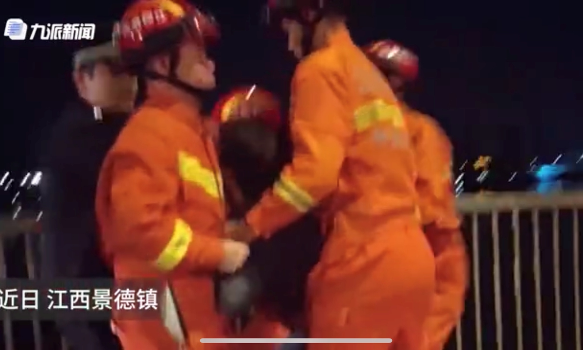 In Jingdezhen, East China's Jiangxi Province, a boy intended to jump off a bridge to his death because he felt lonely and unloved. Fortunately, local firefighters arrived in time to save him and comforted the boy in tears. Photo: Sina Weibo