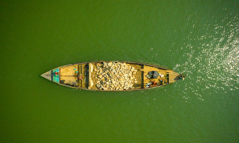 Aerial photo taken on Oct. 24, 2021 shows a boat loaded with stones on the Jadukata river in Sunamganj, Bangladesh. (Photo: Xinhua)