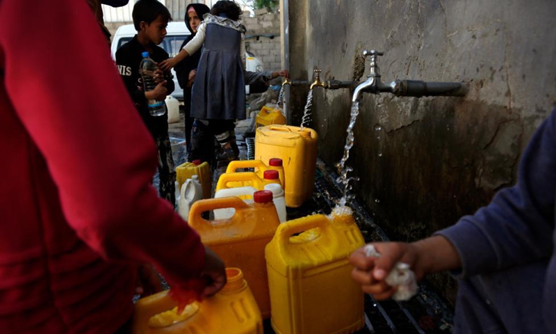 Yemeni children fill plastic containers with water at a charity water tap site in Sanaa, Yemen, on Oct. 28, 2021.Photo:Xinhua