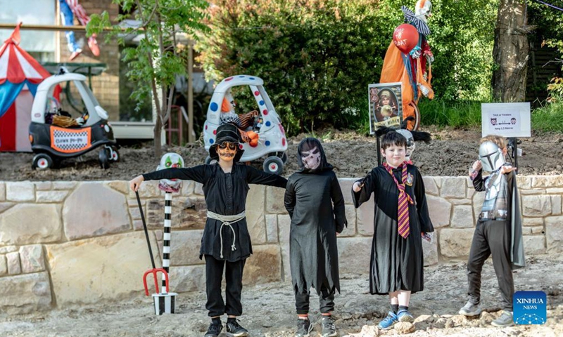 Kids in Halloween costumes pose for a photo in front of a house in Canberra, Australia, Oct. 30, 2021. Residents decorated their houses for the Halloween as coronavirus restrictions in Australia's Canberra have eased significantly. (Photo:Xinhua)  