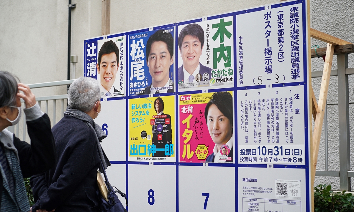 Voters look at an election poster bulletin board for House of Representatives election candidates at an entrance of a polling station in Saitama, Japan on Sunday. Photo: AFP