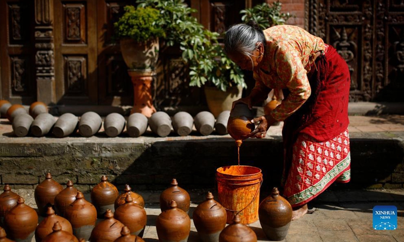 A Nepalese woman prepares clay pots for Tihar, a Hindu festival, at Pottery Square in Bhaktapur, Nepal on Oct. 31, 2021.Photo:Xinhua