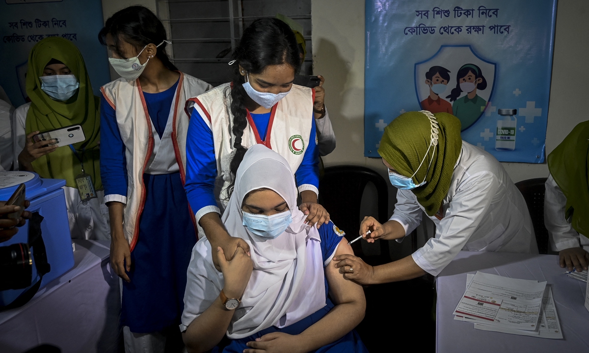 A health worker inoculates a student of a senior class with a jab of COVID-19 vaccine inside a school premises in Dhaka, Bangladesh on Monday as per a directive by the government. Photo: AFP