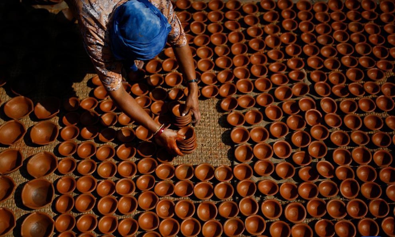 A Nepalese woman prepares clay pots for Tihar, a Hindu festival, at Pottery Square in Bhaktapur, Nepal on Oct. 31, 2021.Photo:Xinhua
