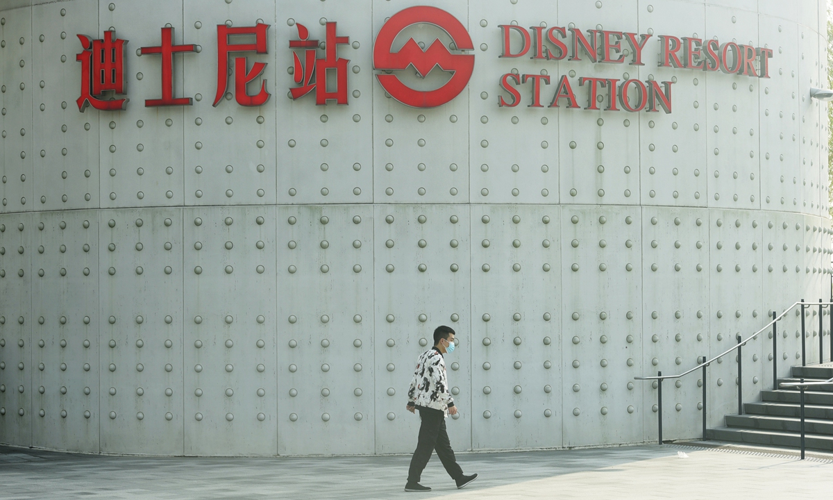 A resident passes by the Disney Resort station on Monday. Photo: IC