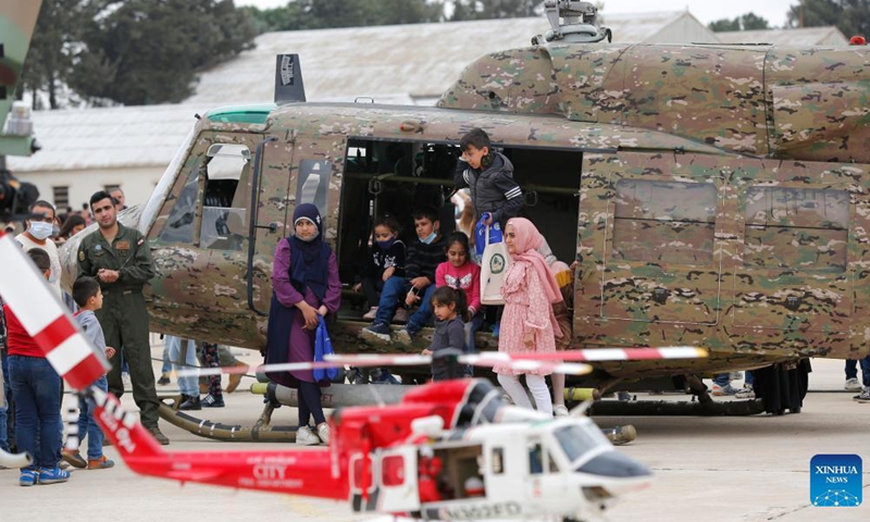 People pose for photos in front of a helicopter during an open day at Rayak Air Base in Bekaa, Lebanon, on Oct. 31, 2021.Photo:Xinhua