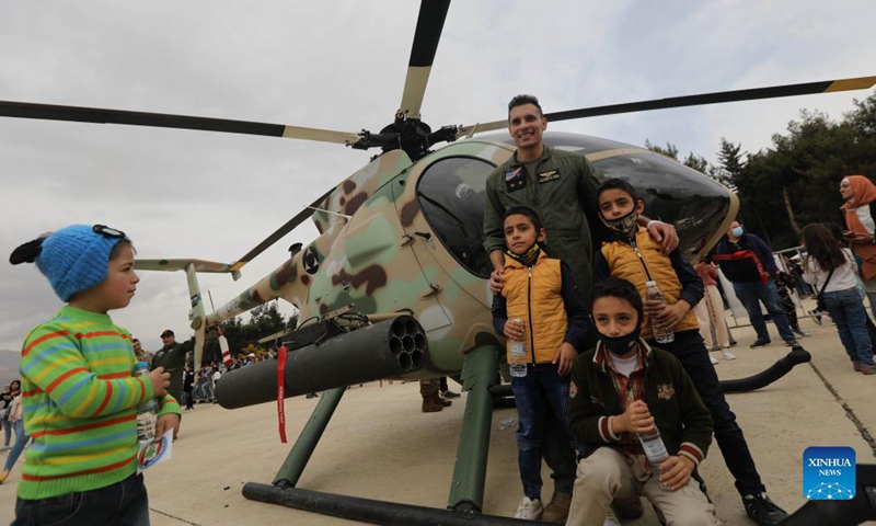 People pose for photos in front of a helicopter during an open day at Rayak Air Base in Bekaa, Lebanon, on Oct. 31, 2021.Photo:Xinhua