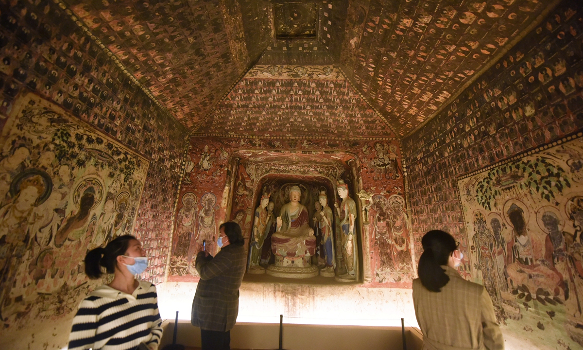 Visitors look at a replica of a cave in the Dunhuang Mogao Grottoes reproduced with 3D digital printing technology at the Zhejiang University Museum of Art and Archaeology in Hangzhou, East China's Zhejiang Province, on November 2, 2021. Photo: VCG