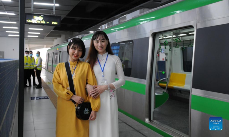 Young ladies pose for a photo with a train at Cat Linh station in Hanoi, Vietnam, Nov. 6, 2021. Authorities of the Vietnamese capital Hanoi inaugurated the China-built Cat Linh-Ha Dong metro line project on Saturday, making it the first metro line in the country to start commercial operation. Photo: Xinhua