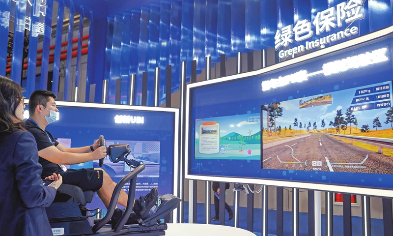 A visitor tries out a simulated driving game at the automobile exhibition area of the 4th China International Import Expo in Shanghai on November 7, 2021. Autonomous driving, smart and connected cars, and new-energy vehicle technologies are among this year's top attractions. Photo: cnsphoto