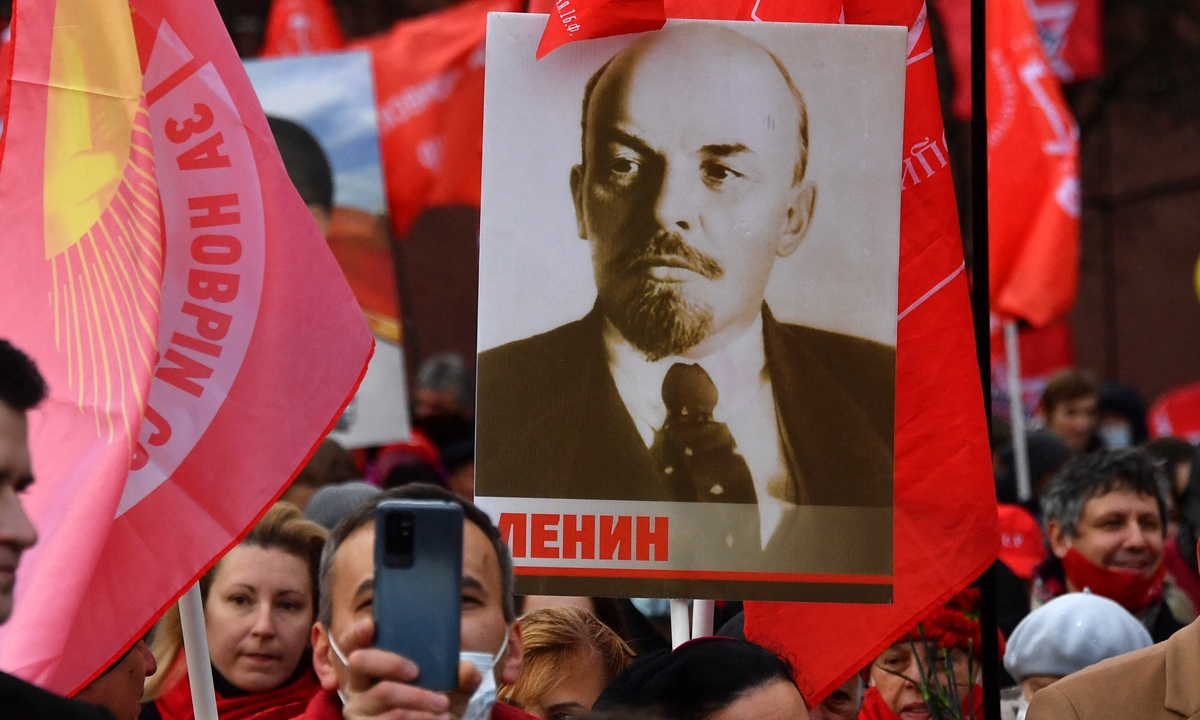 Supporters of the Russian Communist Party take part in a flower and wreath-laying ceremony by Lenin's Mausoleum in Red Square and a memorial complex to Heroes of the Revolution by the Kremlin Wall in Moscow, Russia on November 7, 2021 to mark the 104th anniversary of the 1917 October Revolution.