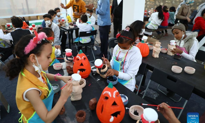 Children try to color pieces of pottery during a pottery exhibition held at Fustat Pottery Village in Cairo, Egypt, Nov. 6, 2021. A two-day pottery exhibition opened on Saturday at the Fustat Pottery Village, with the aim of publicizing traditional Egyptian pottery cultures and reviving pottery industry.Photo: Xinhua
