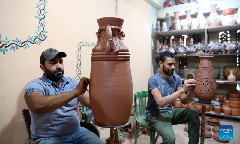 Pottery craftsmen show pottery hollowed-out techniques during a pottery exhibition held at Fustat Pottery Village in Cairo, Egypt, Nov. 6, 2021. A two-day pottery exhibition opened on Saturday at the Fustat Pottery Village, with the aim of publicizing traditional Egyptian pottery cultures and reviving pottery industry. Photo: Xinhua