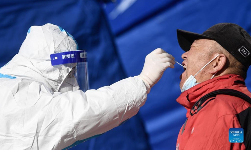 A medical worker takes a swab sample from a citizen for nucleic acid test at a testing site in Chengxi District of Xining, northwest China's Qinghai Province, Nov. 8, 2021. Xining started its second round of mass nucleic acid testing at 9 a.m. on Monday. As of Nov. 7, Xining finished the first round of testing, and all swab samples from 1,448,000 citizens came back negative. (Xinhua/Zhang Long)