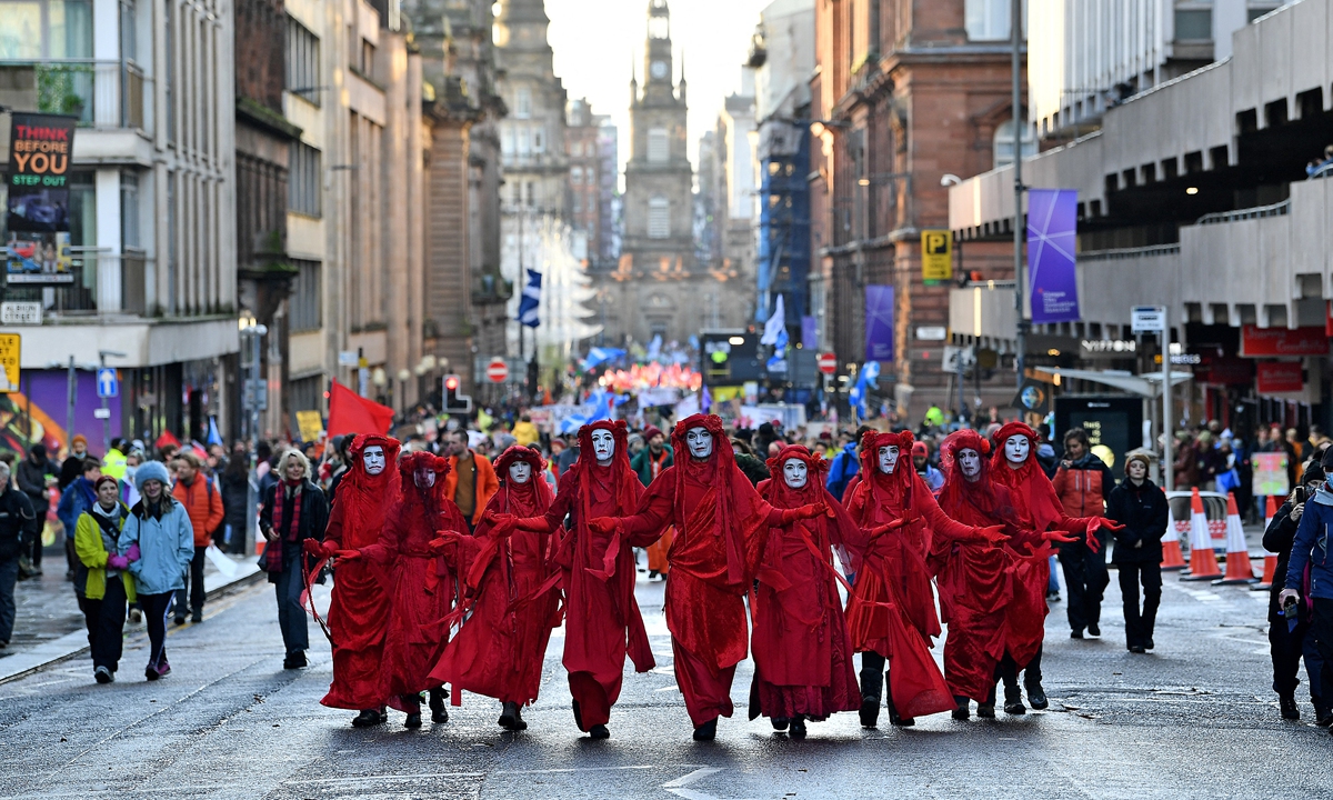 Members of the Red Rebel Brigade, an international performance artivist troupe participate in a protest rally during a global day of action on climate change in Glasgow, the UK on Saturday. Photos: AFP