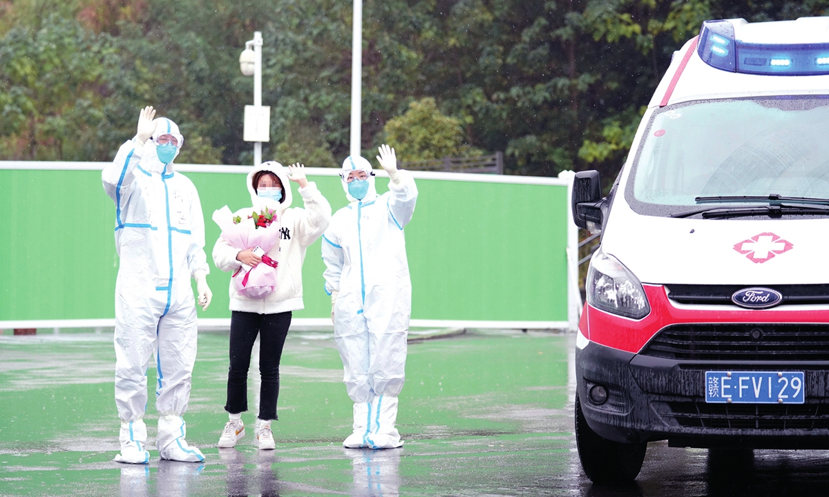 A woman recovered from COVID-19 along with two medical personnel wave after she was discharged from the hospital in Jiangxi Province on November 4, 2021. Photo: VCG 