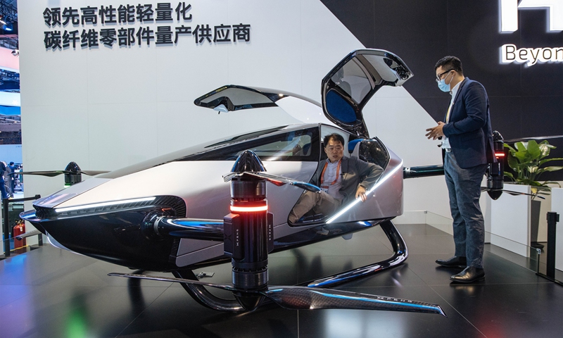 Visitors experience a flying car built by Hengrui Corp at the 4th China International Import Expo (CIIE) in Shanghai on November 8, 2021. The automobile exhibition area at the CIIE is about 30,000 square meters, where more than 50 firms from 13 countries and regions are showing their most advanced developments and achievements. Photo: Li Hao/GT