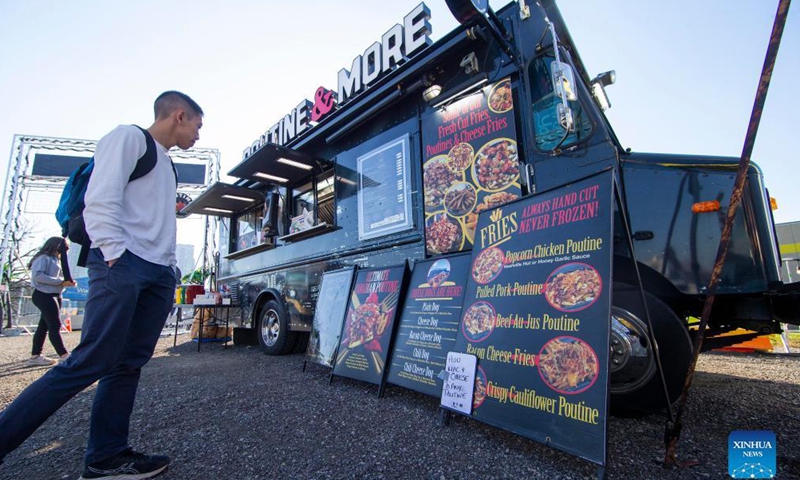 People look at menus in front of a food truck at the Toronto Poutine Festival in Toronto, Canada, on Nov. 7, 2021.Photo:Xinhua