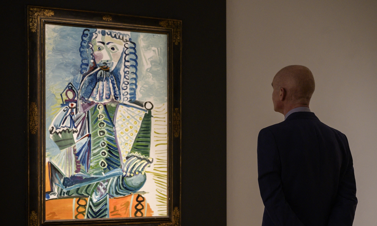 A painting by Pablo Picasso entitled Mousquetaire à la pipe II is displayed at Christie's auction house in New York on October 29. Sotheby's Brooke Lampley (left) and staff take calls for off-site bids during an auction of 11 works by Spanish artist Pablo Picasso from the MGM Resorts Fine Art Collection in Las Vegas on October 23. Photos: AFP 