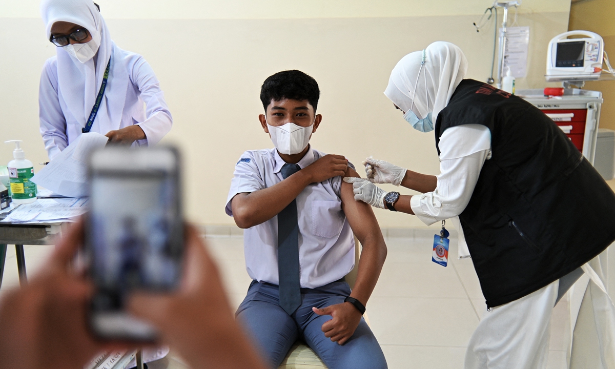 A high-school student receives a dose of the Pfizer COVID-19 vaccine at Zainoel Abidin hospital in Banda Aceh, Indonesia on Tuesday. The country has about 4.25 million infections in total as of Tuesday, with more than 144,000 deaths. Photo: AFP