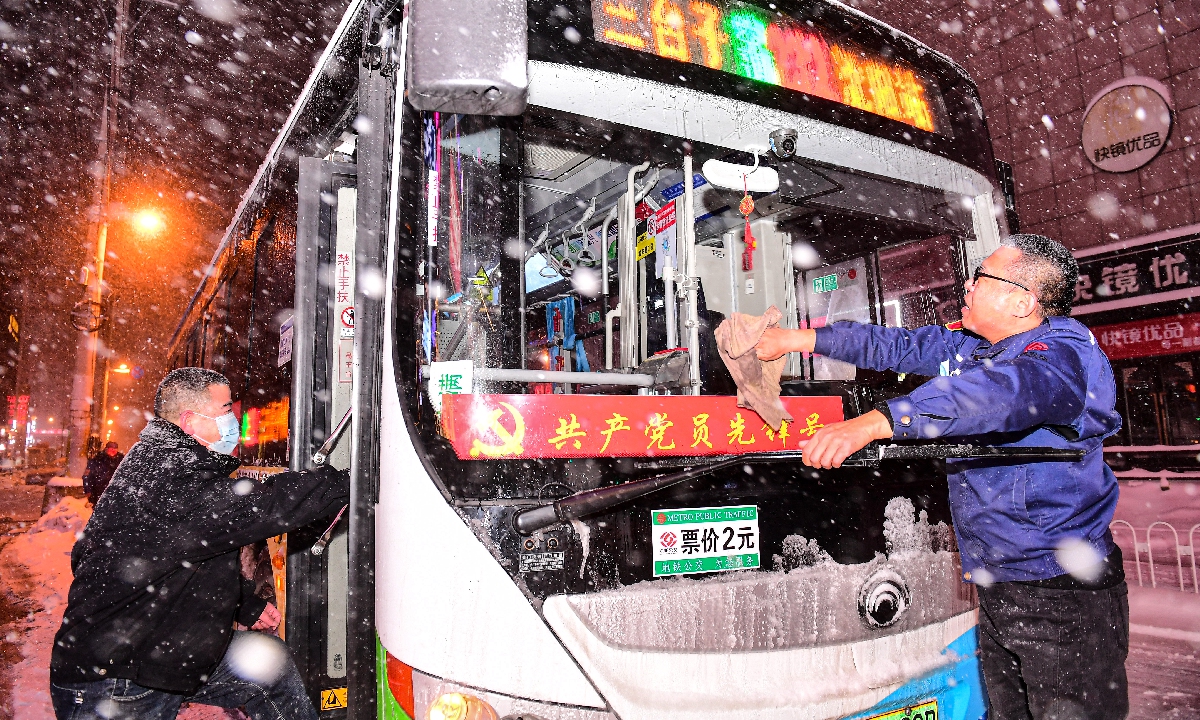 Bus drivers in Shenyang, Northeast China's Liaoning Province, clean snow off a bus on November 8, 2021. The province has been hit hard by heavy snowfalls in recent days. Photo: VCG