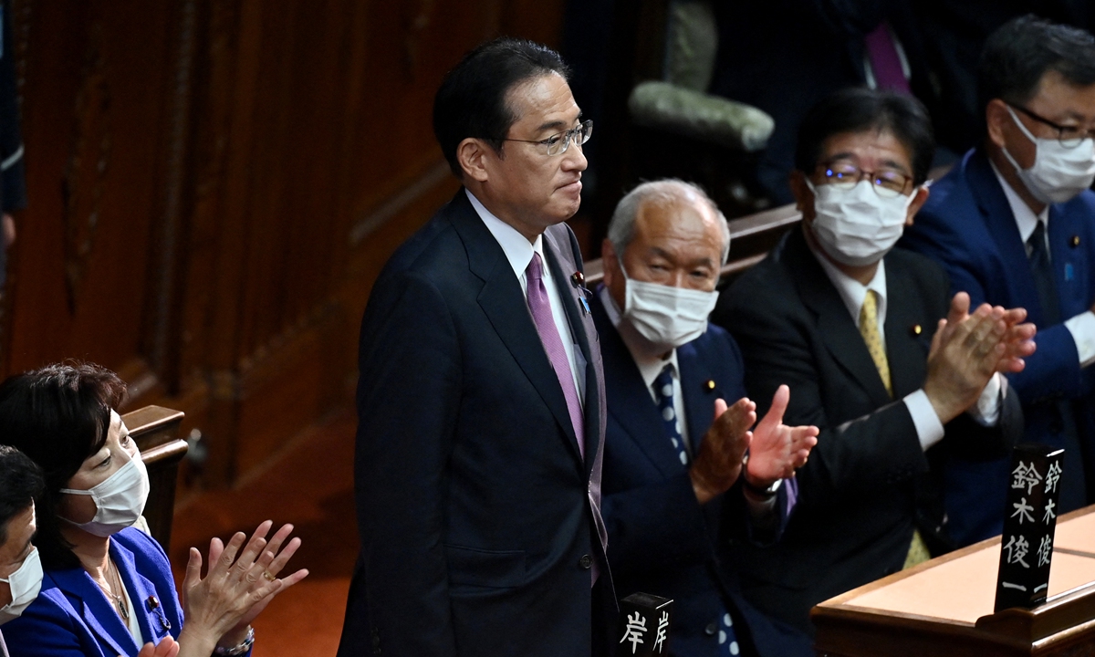 Fumio Kishida (front) is applauded after his position as Japanese prime minister was confirmed during a lower house plenary session of parliament in Tokyo on November 10, 2021. Photo: AFP