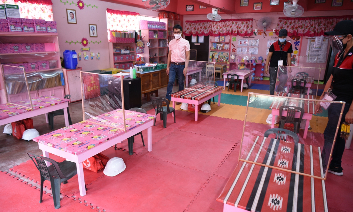 Cipriano Bisco (left), principal of Ricardo P. Cruz Elementary School, inspects one of the kindergarten classrooms in Taguig City, suburban Manila, the Philippines on Wednesday, as the school awaits approval from authorities ahead of the opening of limited face-to-face classes on Monday amid the pandemic. Photo: AFP