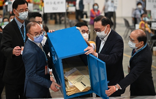 Local officials in Hong Kong together pour out the votes from the voting ballot before counting the votes on September 19, 2021 as the city held its Hong Kong Election Committee subsector election. Photo: IC