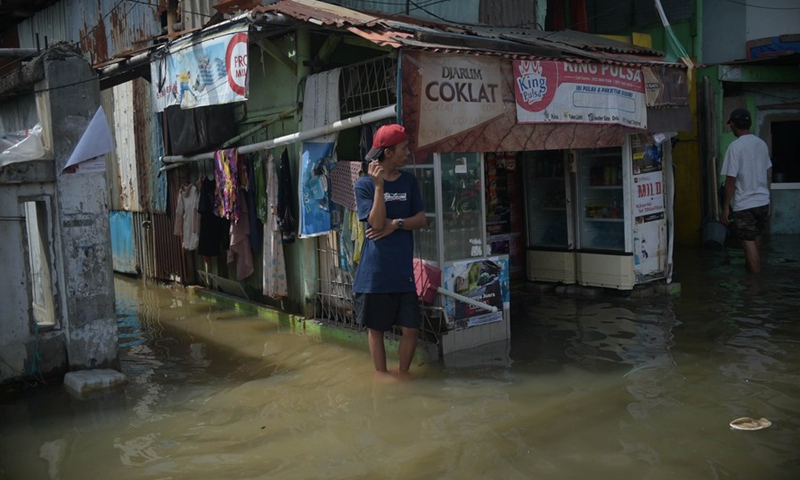 People are seen in the flood water at a neighborhood on the coast of Jakarta, Indonesia, Nov. 9, 2021.(Photo: Xinhua)
