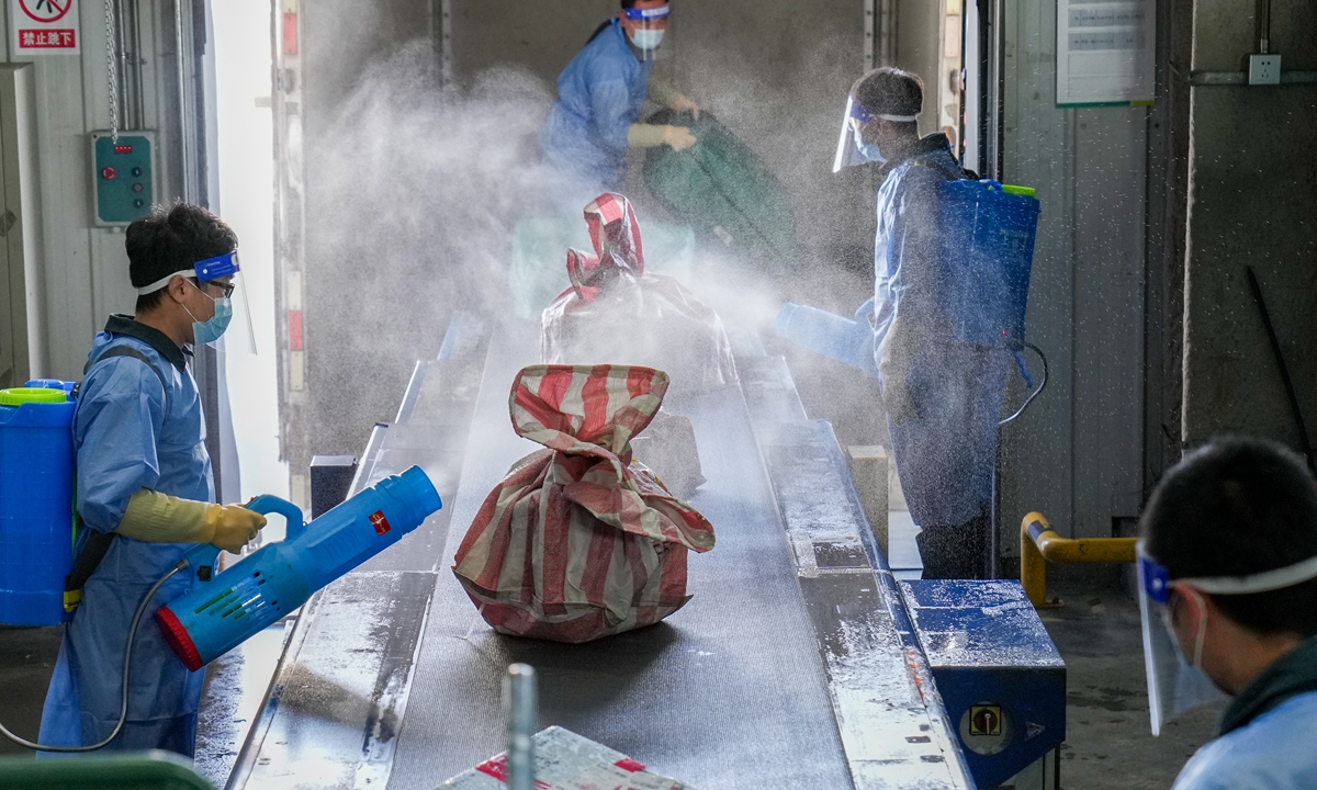 Staffers conduct disinfection on packages arrving from outside the country in the terminal site of Beijing Air Mail Processing Center on November 19, 2021. Photo: CFP
