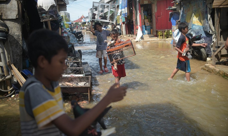 Children are seen in the flood water at a neighborhood in Jakarta, Indonesia, Nov. 9, 2021.(Photo: Xinhua)