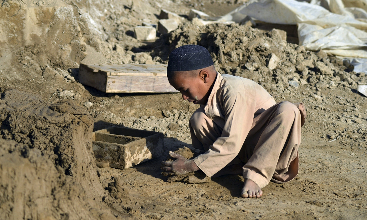A child makes clay bricks with a mould at a brick kiln in Kandahar, Afghanistan on Thursday. International aid agencies say they have only weeks to supply food and other life-saving assistance to remote provinces of Afghanistan before the winter cuts the regions off for months, as the country faces the world's worst humanitarian crisis. Photo: AFP