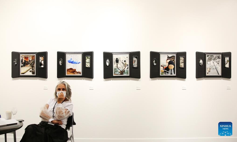 A staff member waits for visitors during a media preview of the 2021 Paris Photo at Grand Palais Ephemere in Paris, France, Nov. 10, 2021. The event is slated to be held from Nov. 11 to 14. (Xinhua/Gao Jing)